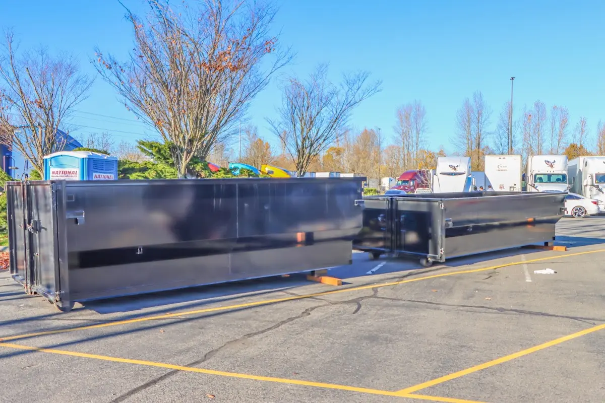Professional dumpster rental service with roll-off container on residential driveway in Fayetteville